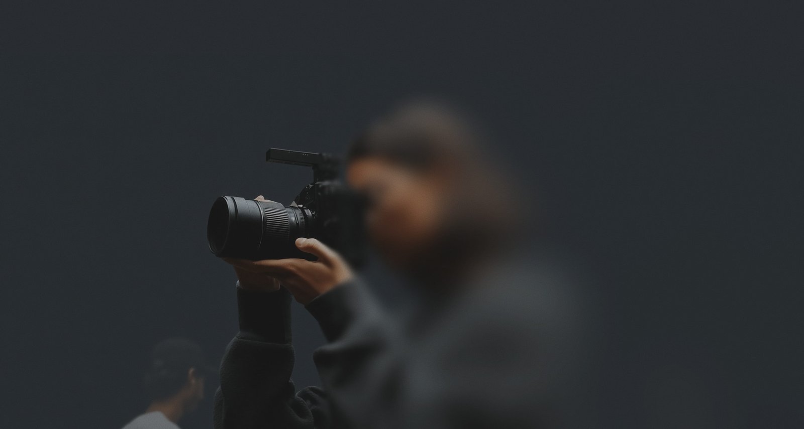 A blurry photo of a person holding a camera.